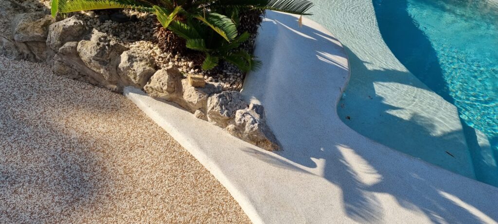 Detalle del pavimento de árido alrededor de piscina con perímetro curvo